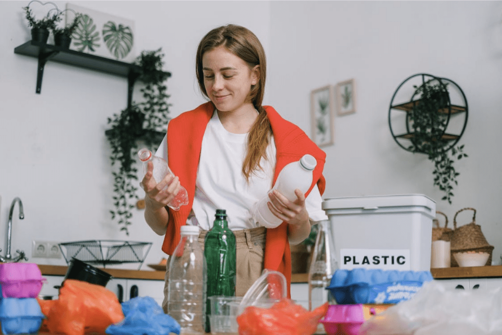 jeune femme qui recycle des bouteilles d'eau en plastique